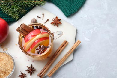 Photo of Aromatic hot mulled cider on light grey marble table, flat lay. Space for text