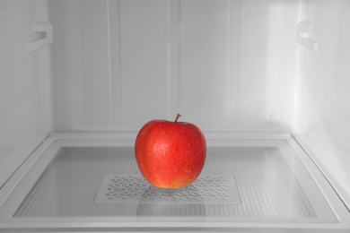 Red apple on shelf inside modern refrigerator