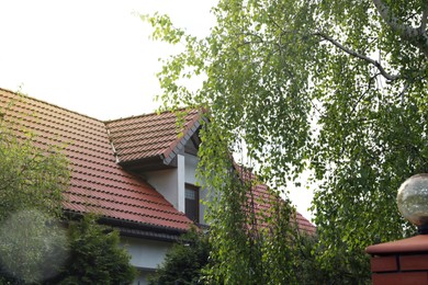 Photo of Modern building with red roof outdoors on spring day