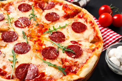 Hot delicious pepperoni pizza on dark table, closeup