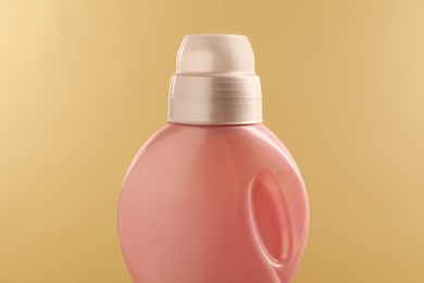 Bottle with detergent on beige background, closeup