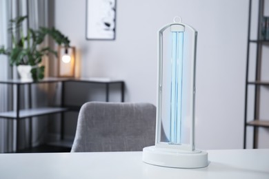 UV sterilizer lamp on table at home. Space for text