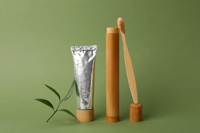 Bamboo toothbrush, paste and case on green background. Conscious consumption