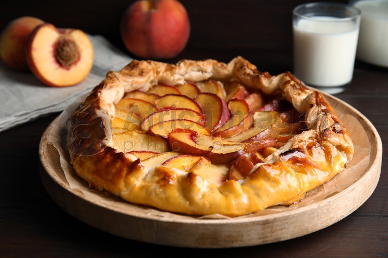 Delicious peach pie and fresh fruits on wooden table, closeup