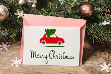 Greeting card with text Merry Christmas on wooden table, closeup