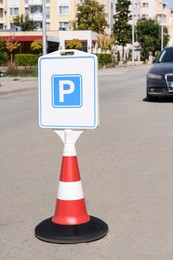 Traffic cone with road sign Parking place on sunny day outdoors