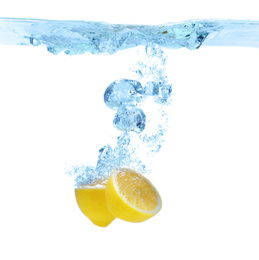 Cut lemon falling down into clear water against white background