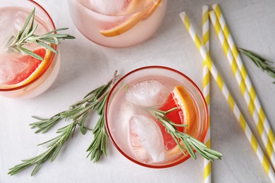 Flat lay composition with grapefruit cocktail and rosemary on gray table