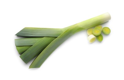 Whole and cut fresh leeks on white background, top view