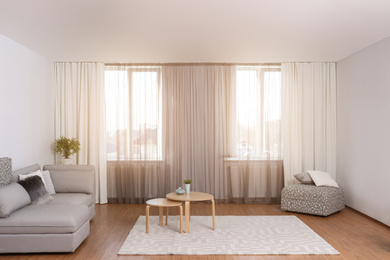 Windows with stylish curtains in living room interior