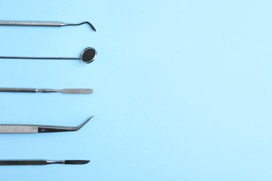 Set of dentist tools on color background, top view with space for text