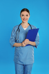 Doctor with stethoscope and clipboard on blue background