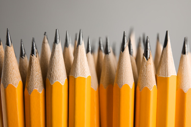 Many graphite pencils on grey background, closeup