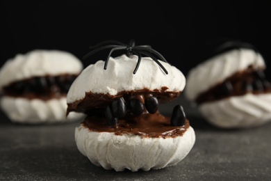 Delicious desserts decorated as monsters on grey table. Halloween treat