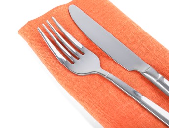 Photo of Orange napkin with fork and knife on white background, closeup