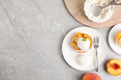 Delicious peach dessert with ice cream on light marble table, flat lay. Space for text
