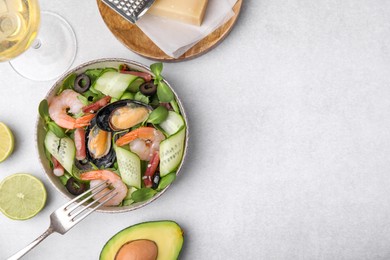 Photo of Bowl of delicious salad with seafood on light grey table, flat lay. Space for text