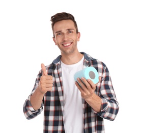 Young man holding toilet paper roll on white background