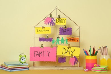 Happy International Family Day. Composition with stationery and cards on table against beige background