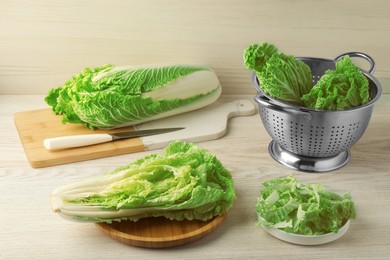 Whole and cut fresh ripe Chinese cabbages on white wooden table