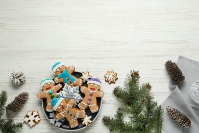 Delicious Christmas cookies, pine cones and fir branches on white wooden table, flat lay. Space for text