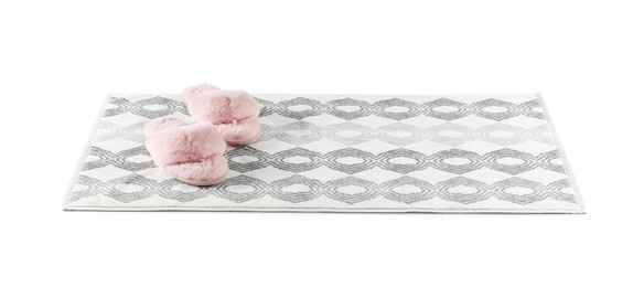 New bath mat with fluffy slippers isolated on white