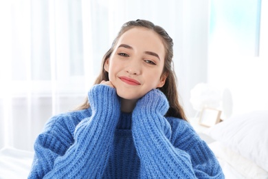 Beautiful teenage girl in warm cozy sweater at home