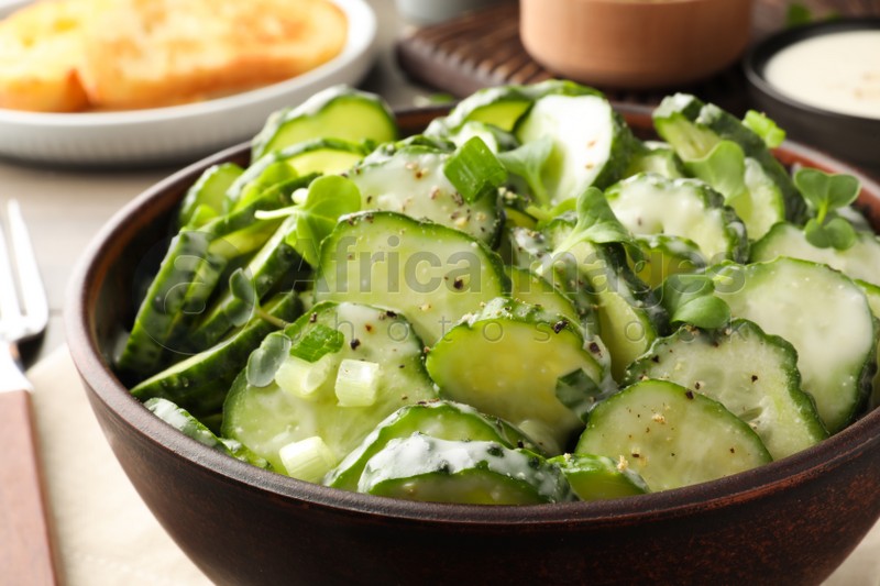 Bowl of delicious cucumber salad on table, closeup