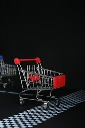 Photo of Competition concept. Red shopping cart crossing finish line