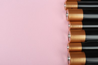 New AA batteries on pink background, above view. Space for text