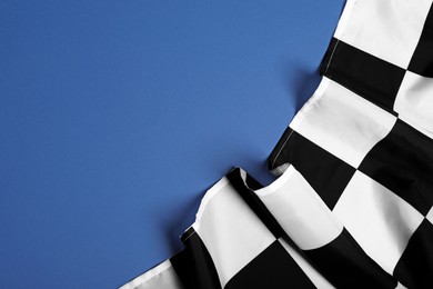 Checkered finish flag on blue background, top view. Space for text