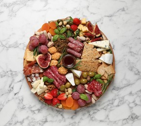 Different tasty appetizers on white marble table, top view