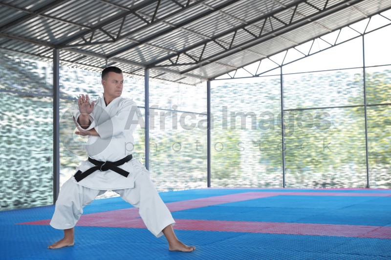CHERNOMORKA, UKRAINE - JULY 10, 2020: Mature man practicing karate on training ground, space for text