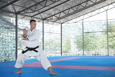 CHERNOMORKA, UKRAINE - JULY 10, 2020: Mature man practicing karate on training ground, space for text