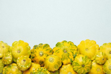Fresh ripe pattypan squashes on light background, flat lay. Space for text