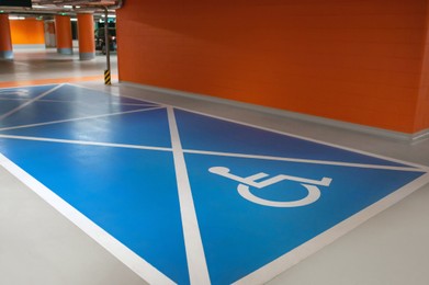 Photo of Empty car parking garage with wheelchair symbol