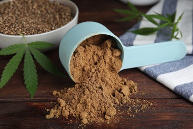 Photo of Hemp protein powder, seeds and fresh leaf on wooden table, closeup