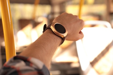 Man with smart watch in bus, closeup