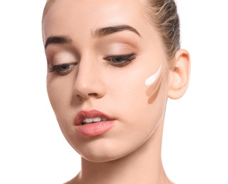 Young woman with different shades of skin foundation on her face against white background. Professional makeup