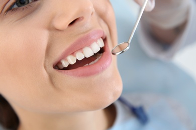 Dentist examining patient's teeth in modern clinic, closeup