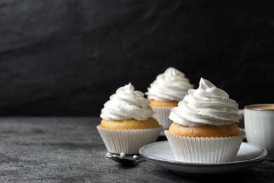 Delicious cupcakes with cream on grey table. Space for text