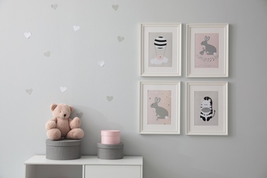 Stylish baby room interior with chest of drawers and cute pictures on wall