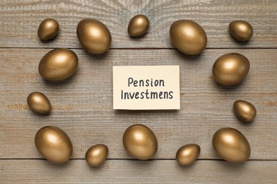 Golden eggs and card with phrase Pension Investments on wooden table, flat lay