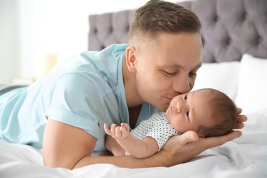 Man with his newborn baby on bed