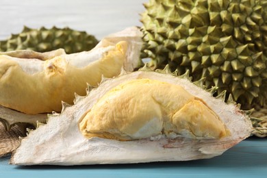 Fresh ripe durians on light blue wooden table, closeup
