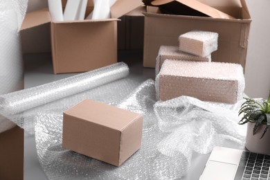 Photo of Table with laptop, boxes and bubble wrap in warehouse