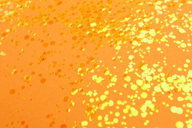 Shiny bright yellow glitter on pale coral background