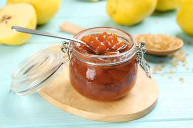 Delicious quince jam on light blue wooden table, closeup