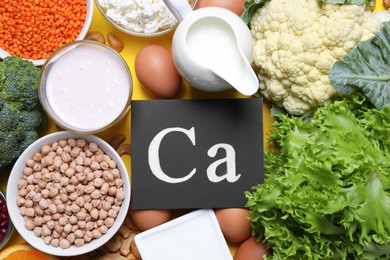 Photo of Food high in calcium. Flat lay composition with different products on yellow background