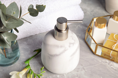 Marble soap dispenser and toiletries on grey table